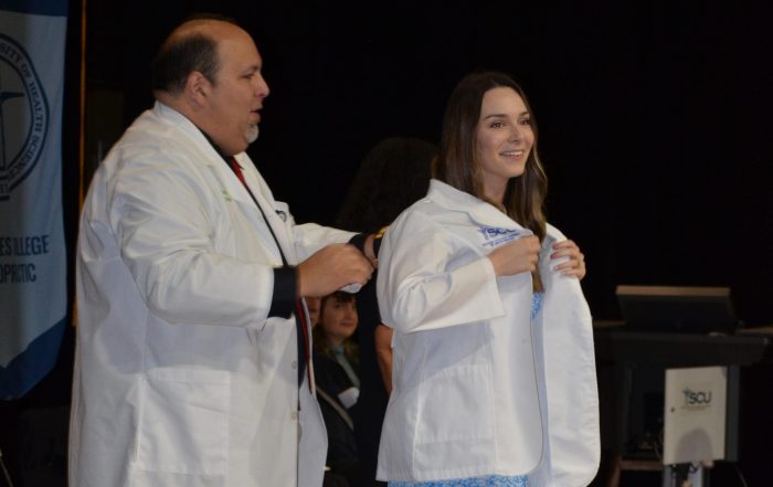 A SCU DC student receives her first white coat during the Spring 2023 DC White Coat Ceremony.